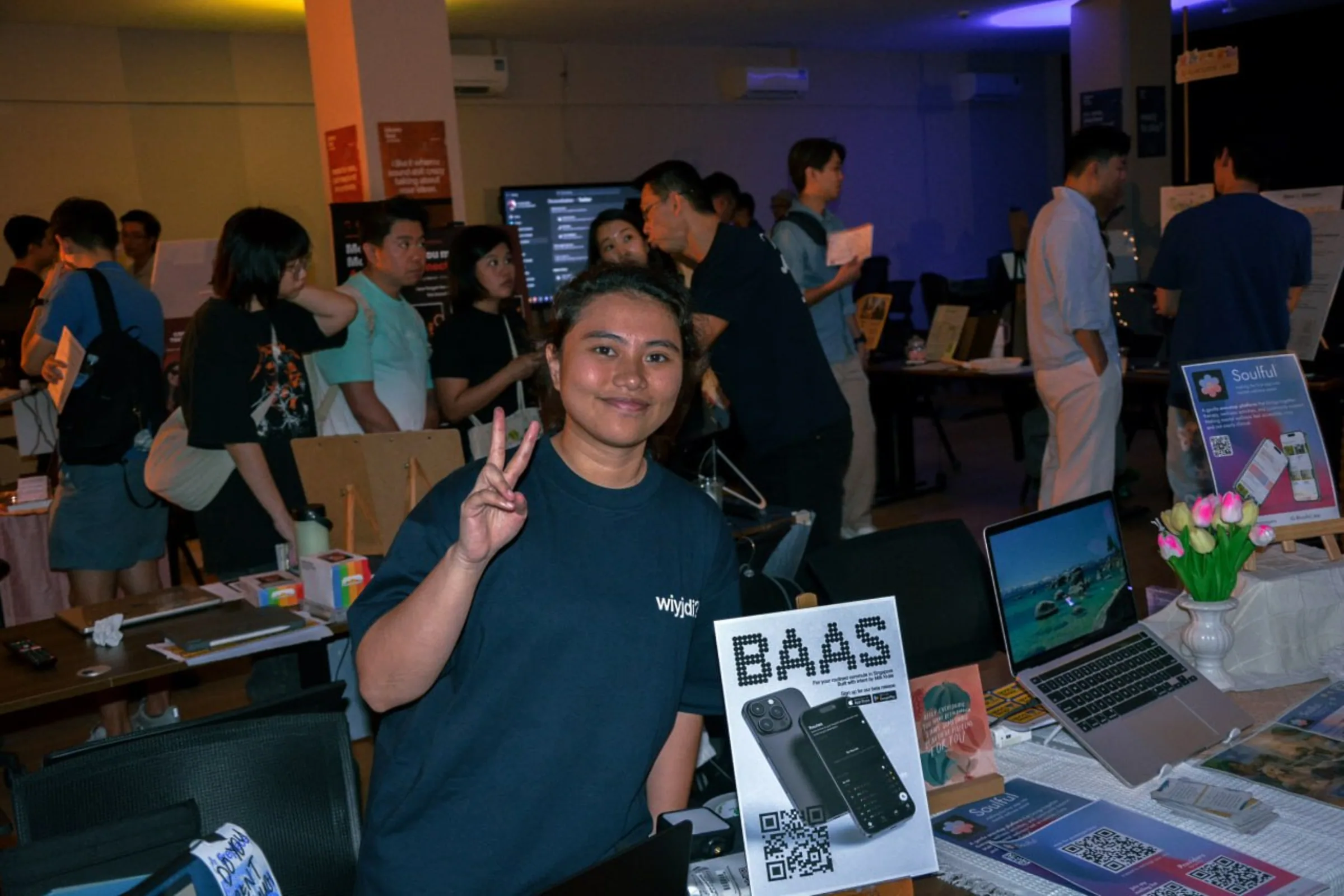 Someone at the BAAS stand at a showcase, with the beta poster and its QR code on the table.